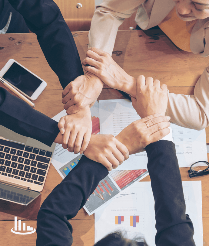 A team joining hands over research and data, representing collaborative action
