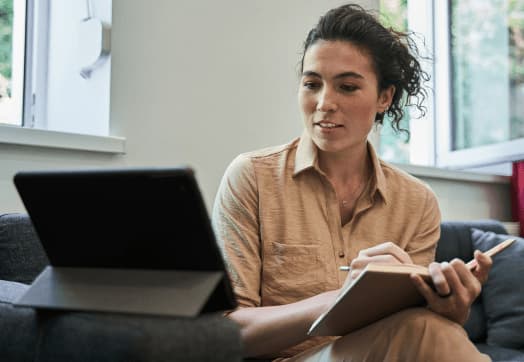 A woman engaged and taking notes, a moment of learning and reflection